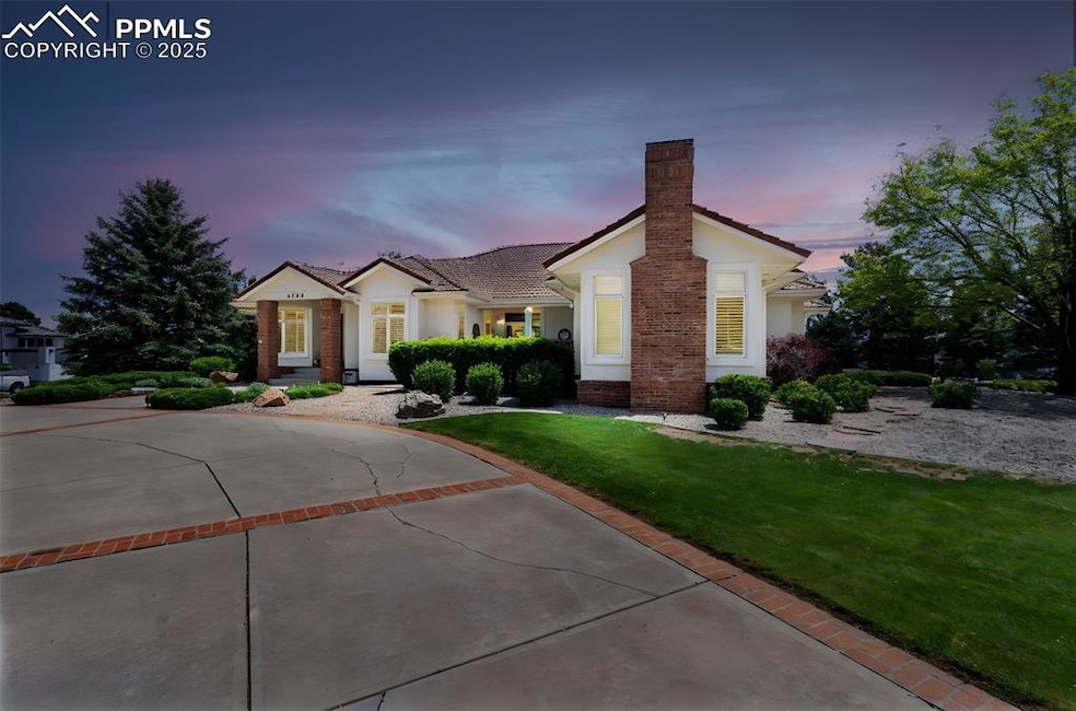 Single story home featuring a chimney, stucco siding, a front yard, and a tile roof