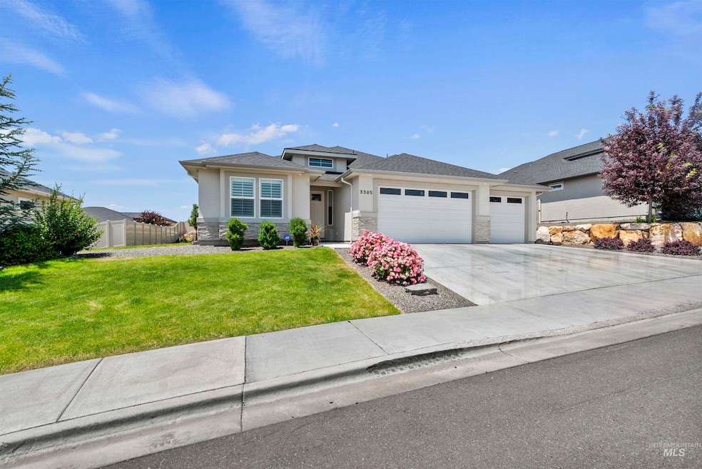 Prairie-style home with an attached garage, driveway, stucco siding, and stone siding