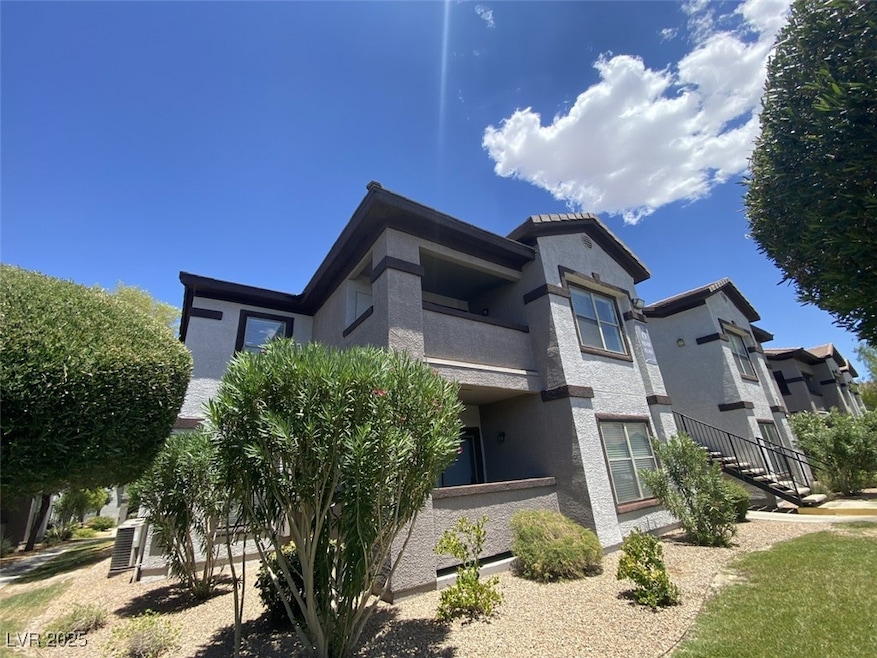 Back of property featuring stucco siding, a balcony, and stairway
