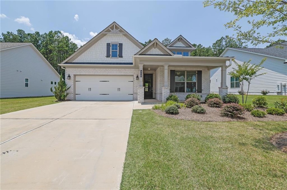 Craftsman inspired home featuring driveway, a front lawn, brick siding, and a porch