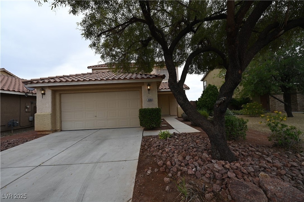 View of front of home with driveway, a tile roof,