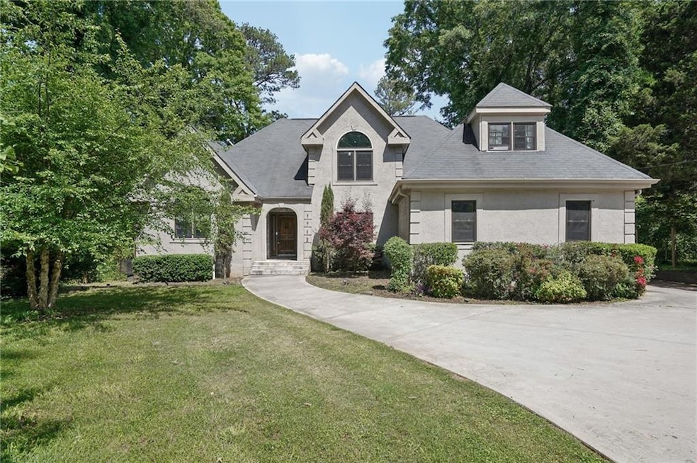 View of front facade with a front lawn and stucco 