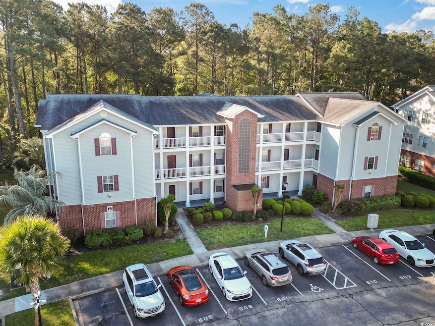 View of building exterior with uncovered parking