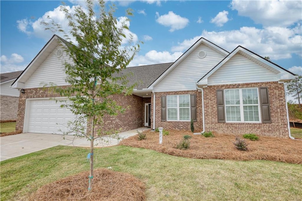 Single story home featuring a front yard and a gar