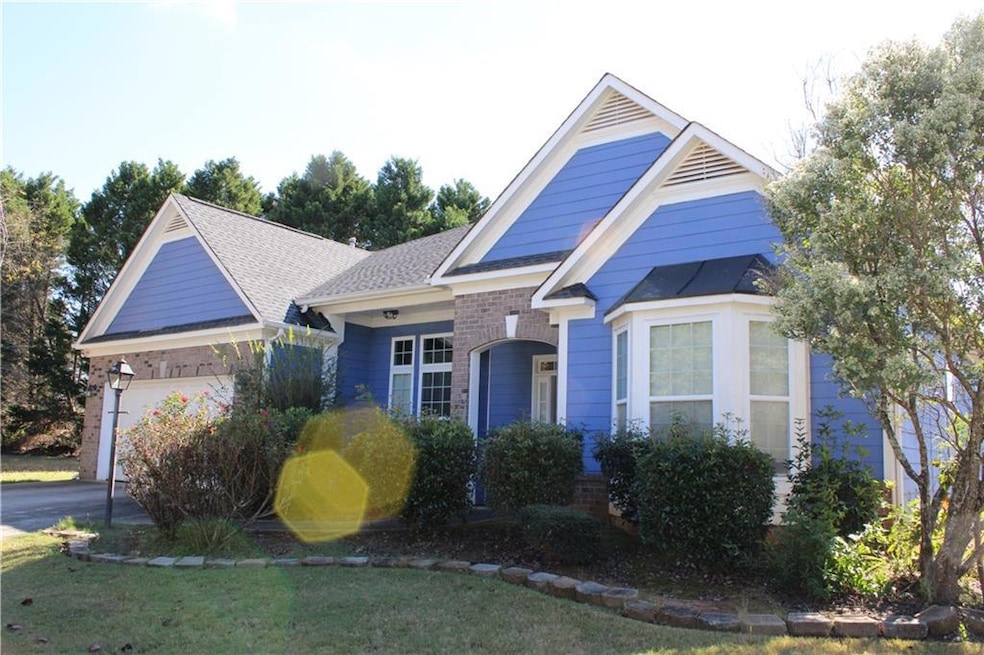 View of front of home featuring an attached garage, a shingled roof, and driveway