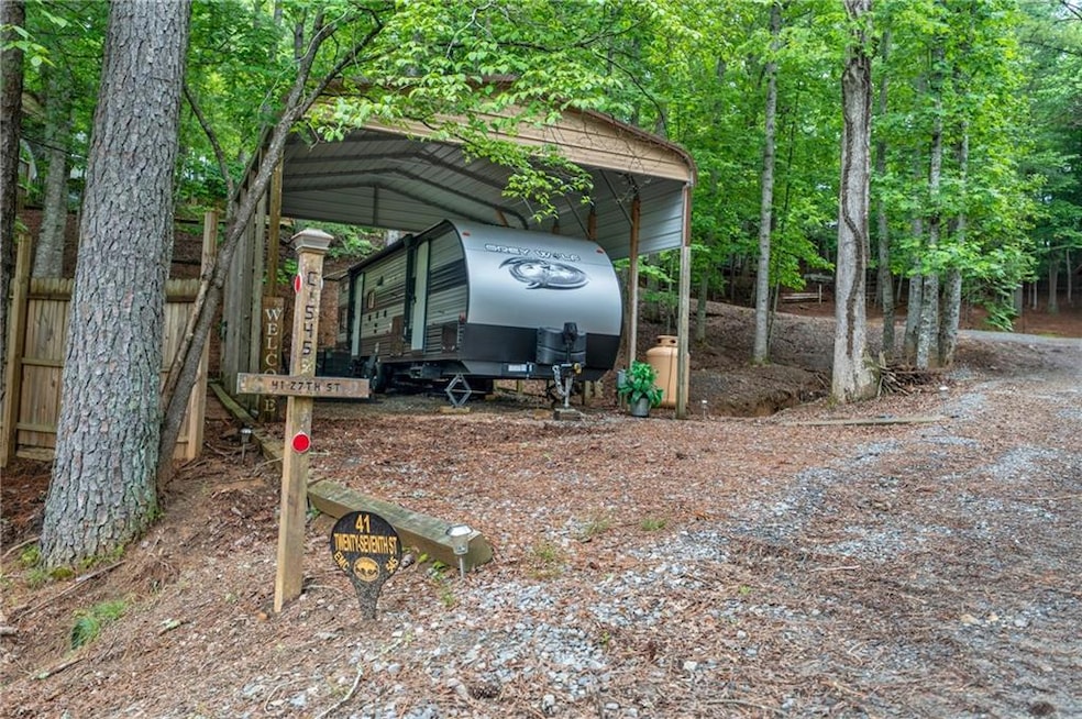 View of outdoor structure featuring a detached carport and dirt driveway