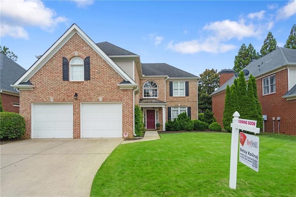 View of front facade with concrete driveway, a front lawn, brick siding, and a garage