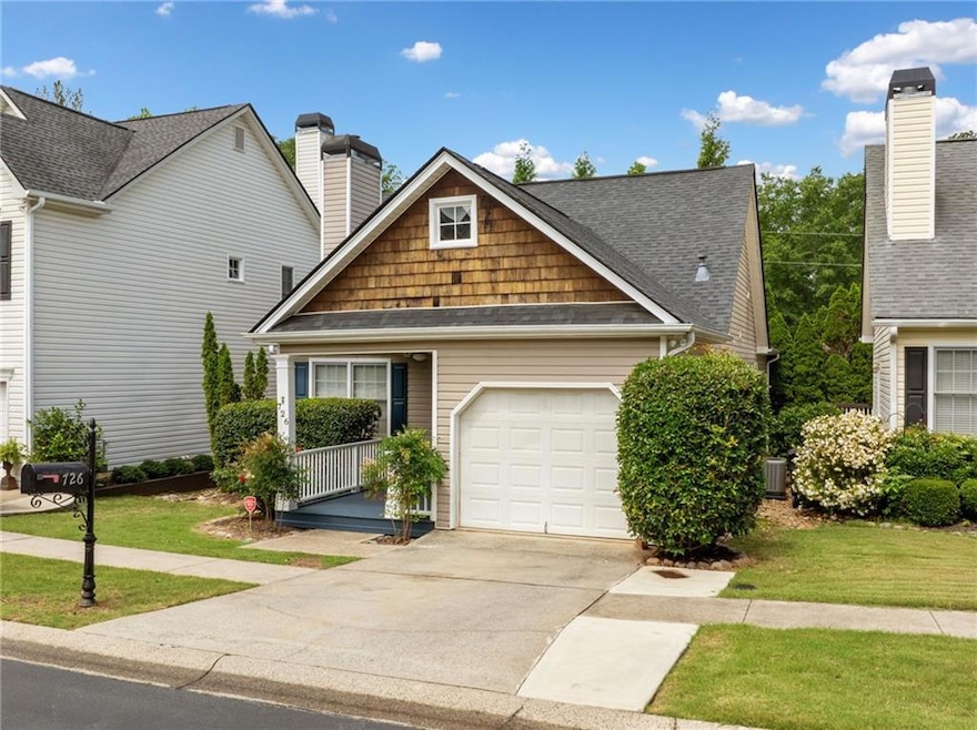 View of front of property with a garage, driveway, a front yard, a chimney, and roof with shingles