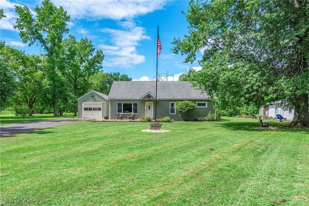 View of front of home with driveway, a front lawn, and a garage