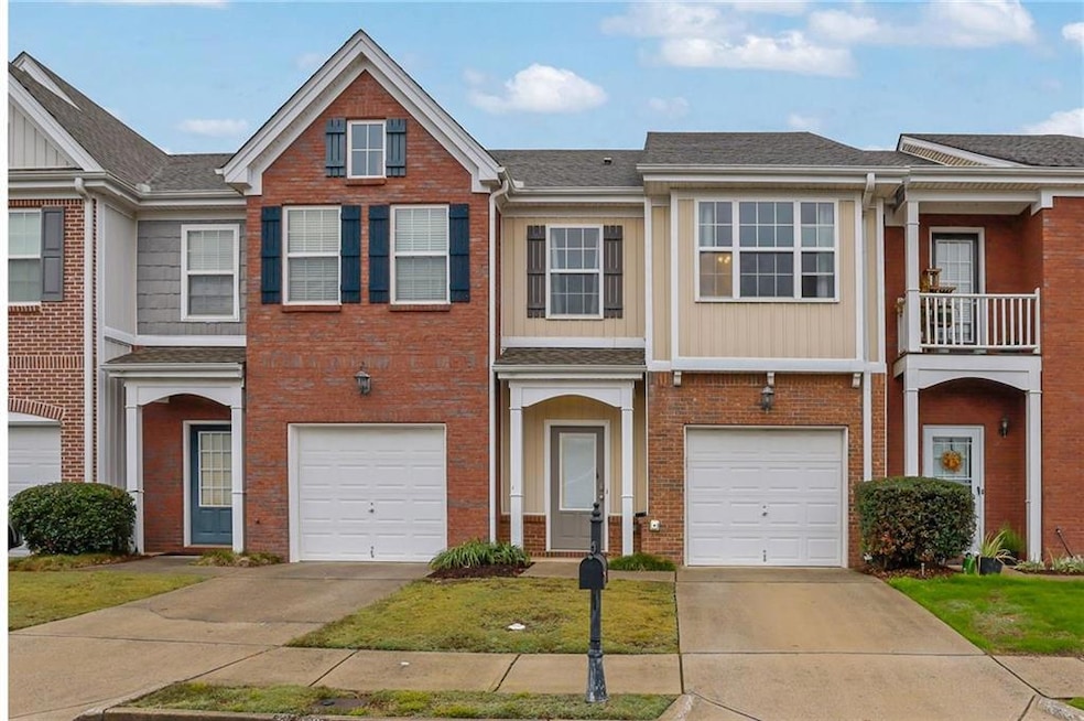 Traditional home featuring driveway, a balcony, roof with shingles, brick siding, and a residential view