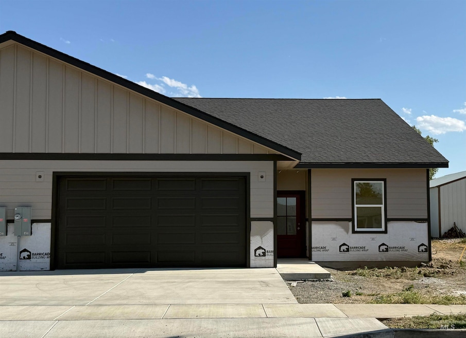 View of front of home with a garage, driveway, and roof with shingles