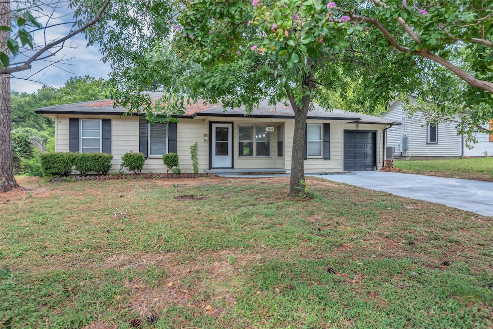Ranch-style house featuring concrete driveway, a front yard, and a garage