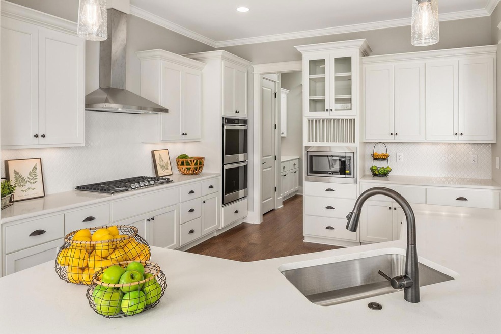 Custom cabinetry in this gourmet kitchen features: display cabinets,  staggered heights, crown molding, hidden hinges and soft close feature.