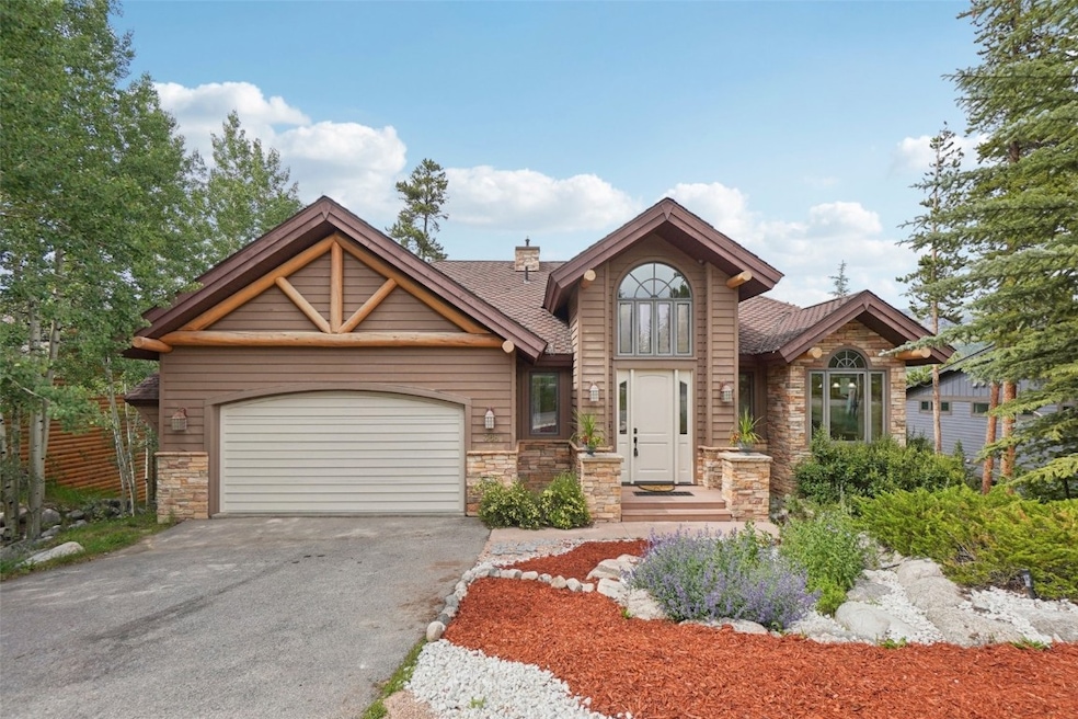 View of front of house featuring stone siding, a g