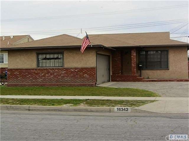 Front of Home with brick work and planter.