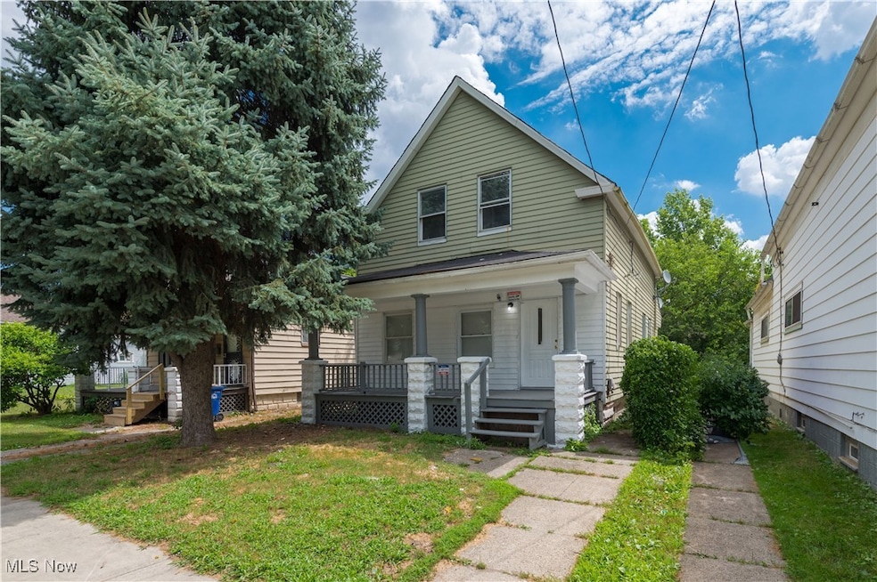 Shotgun-style home with covered porch and a front yard
