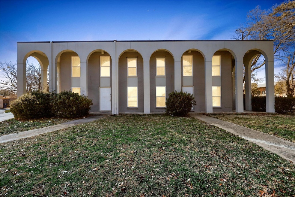 View of front facade with a front yard and stucco 