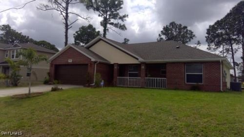 Ranch-style house featuring driveway, brick siding