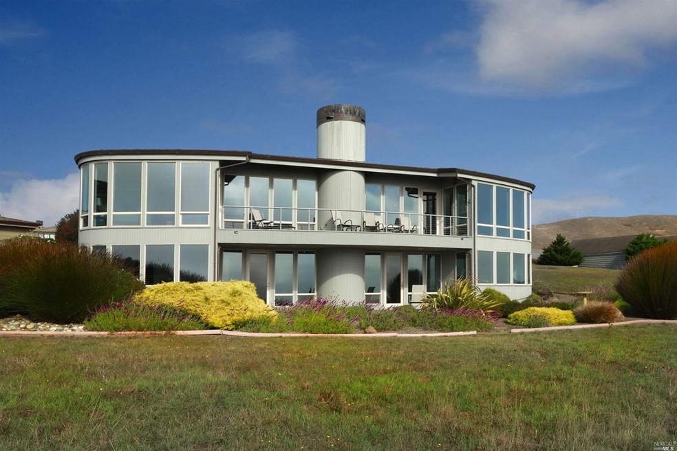 Rear of home from open space showing walls of glas