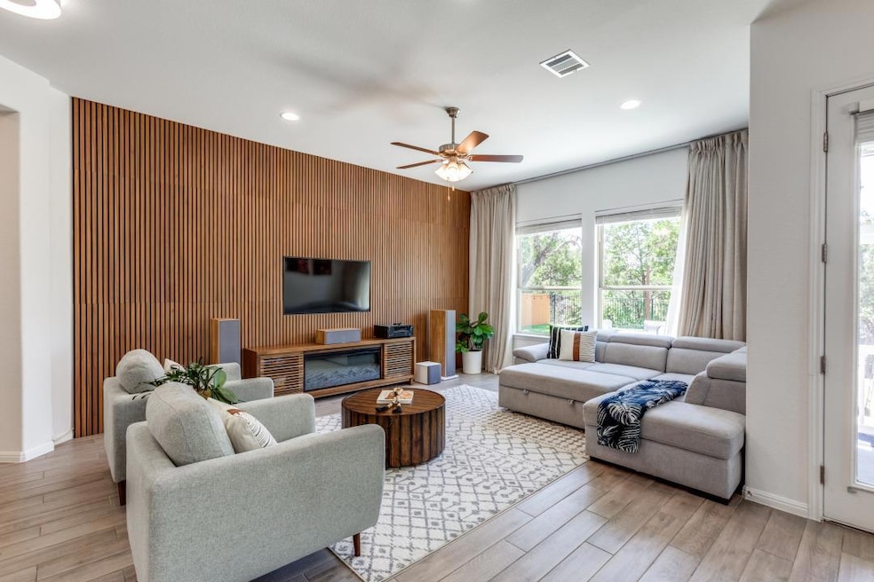Living area featuring an accent wall, light wood-