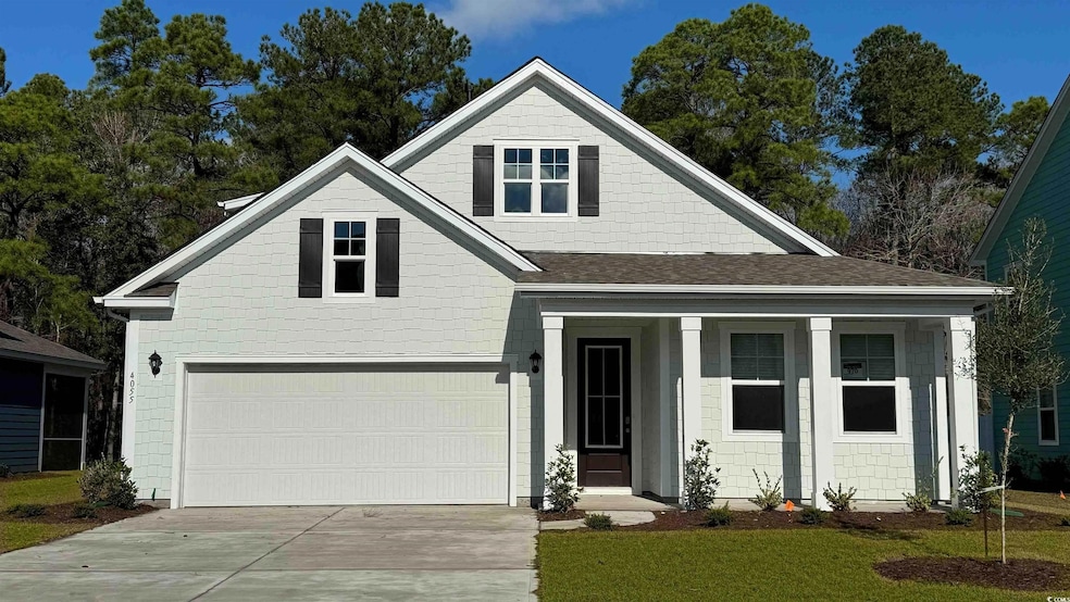 View of front of property with an attached garage, driveway, a porch, a shingled roof, and a front yard