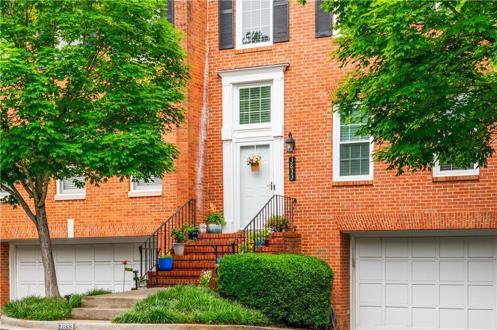 View of exterior entry featuring an attached garage and brick siding