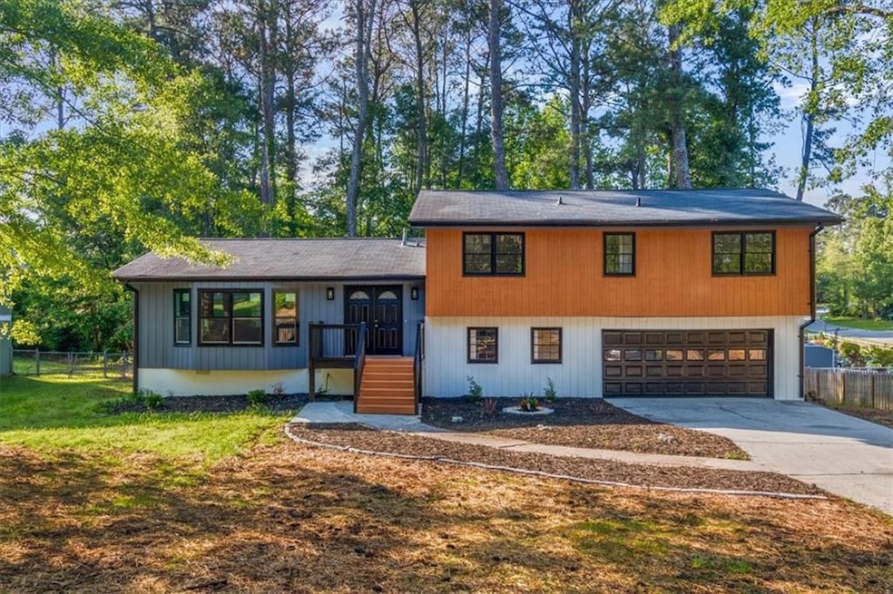 Split level home featuring an attached garage, fen