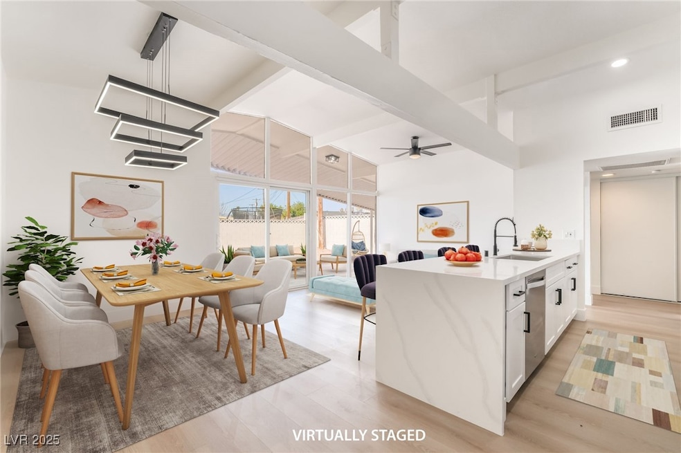 Kitchen featuring high vaulted ceiling, a sink, be