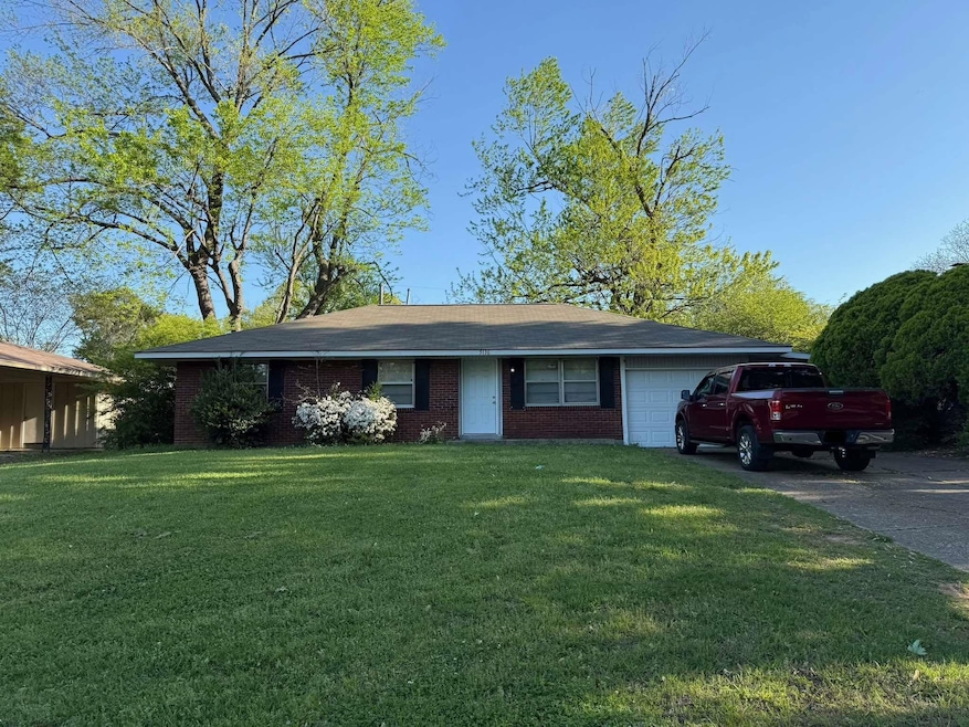 Ranch-style home with a garage, brick siding, a fr