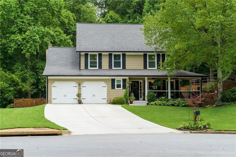 View of front of property with concrete driveway, a porch, a garage, and roof with shingles