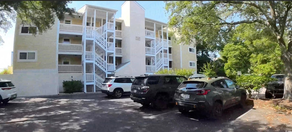 View of apartment building / complex with uncovered parking