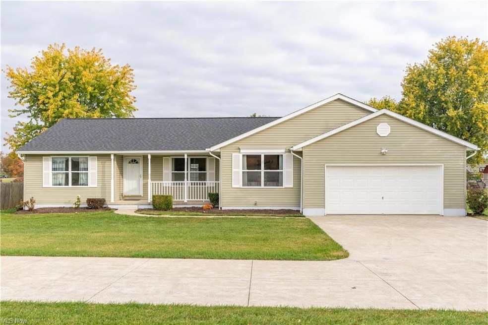 Ranch-style home featuring a covered porch, a gara
