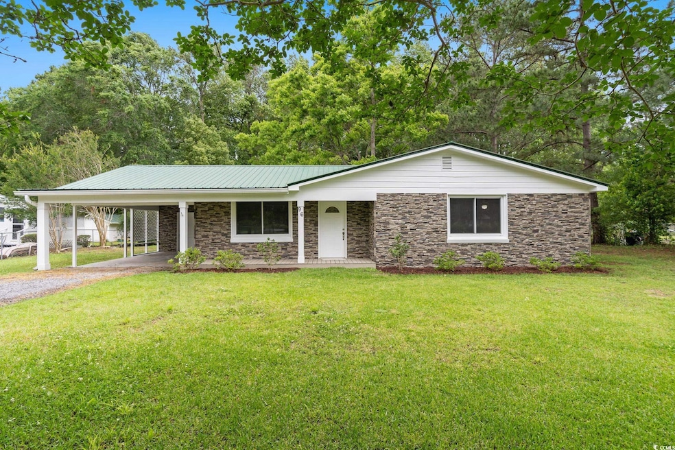 Ranch-style home with driveway, stone siding, a ca