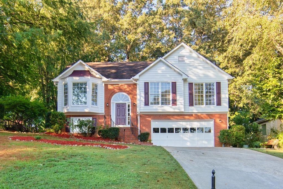 Split foyer home featuring a front lawn and a gara