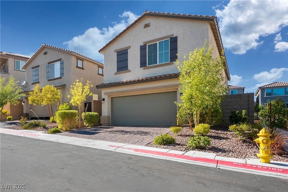 Mediterranean / spanish home featuring a garage, a tile roof, stucco siding, and decorative driveway