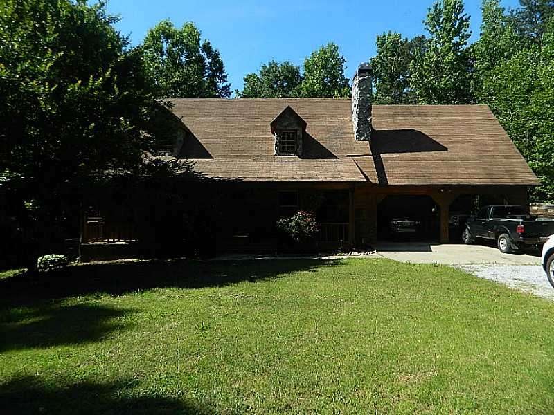 Exterior Front. Rustic cedar and rock sits on priv