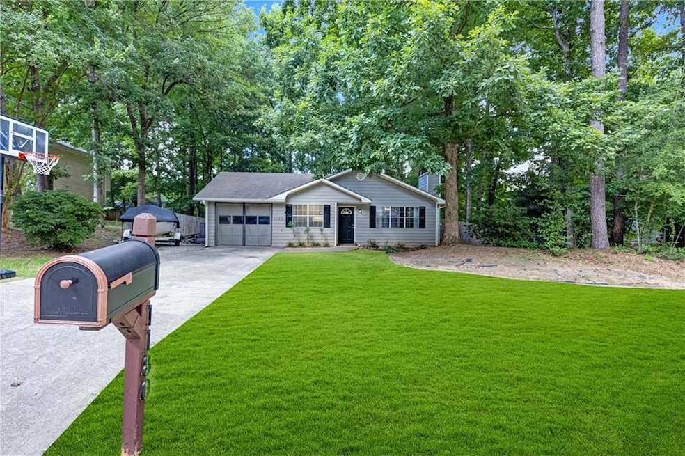 Ranch-style home featuring an attached garage, a front yard, and driveway