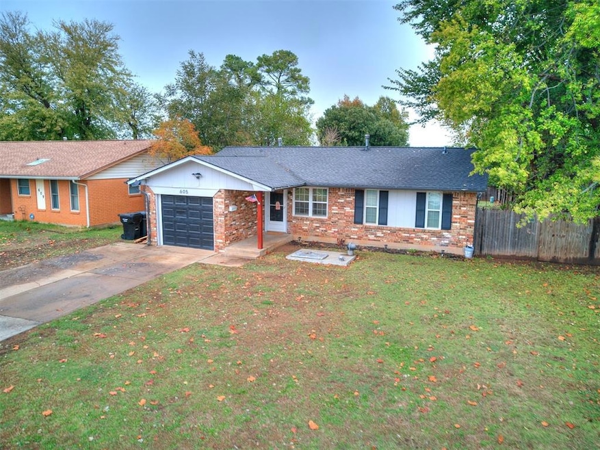 Single story home featuring a garage, brick siding, and concrete driveway