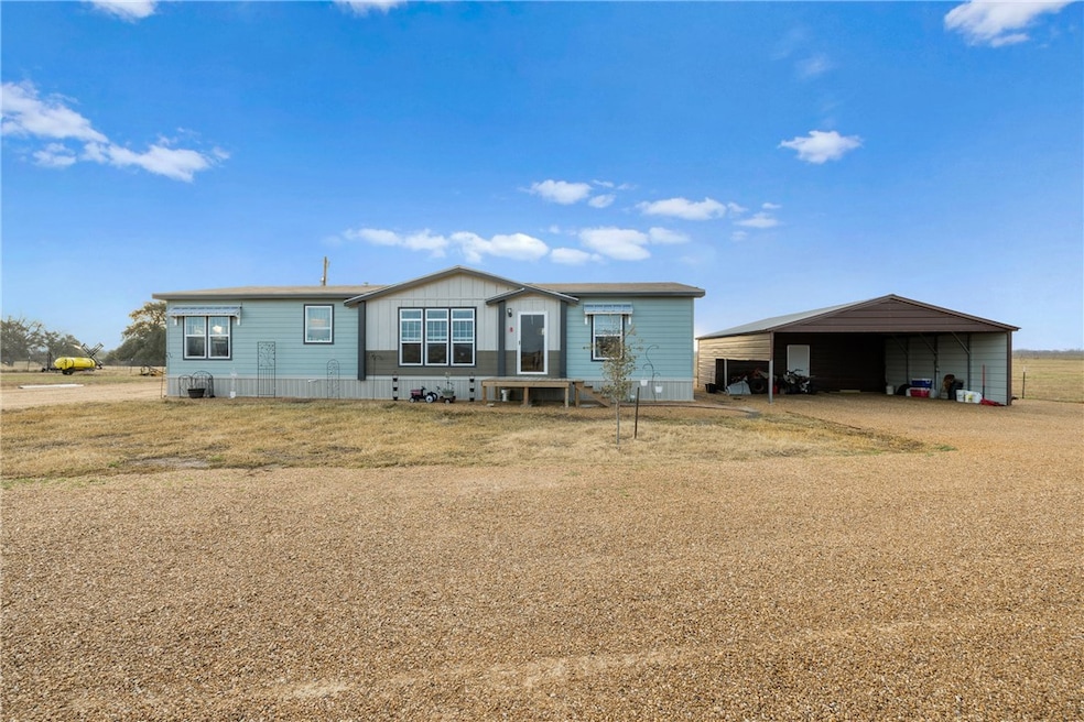 Back of house featuring dirt driveway and a detach