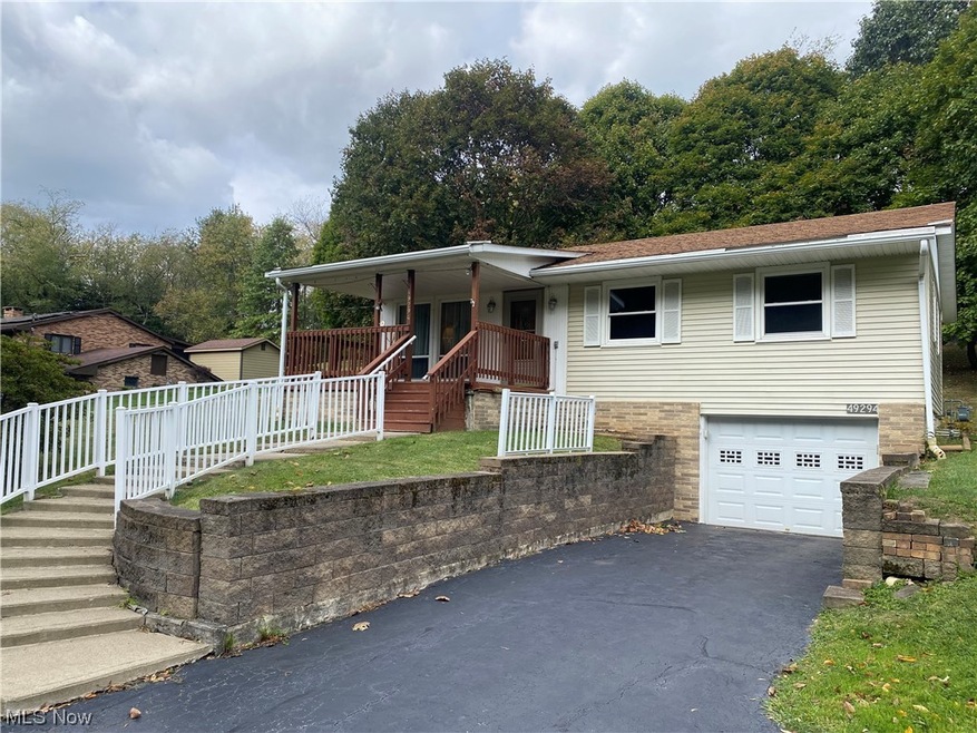 View of front of property featuring a garage and covered porch