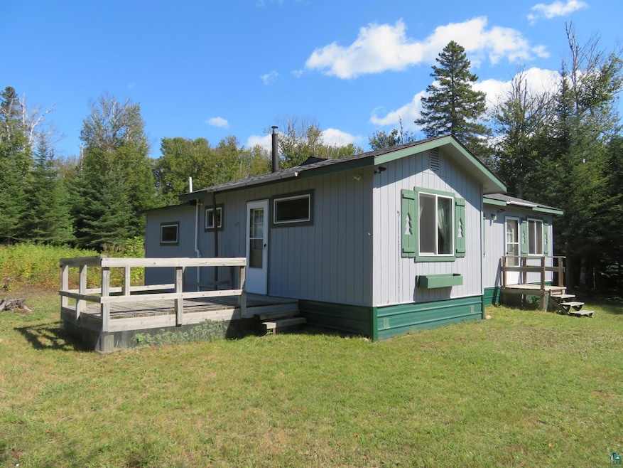 View of front of house featuring a front lawn and a wooden deck