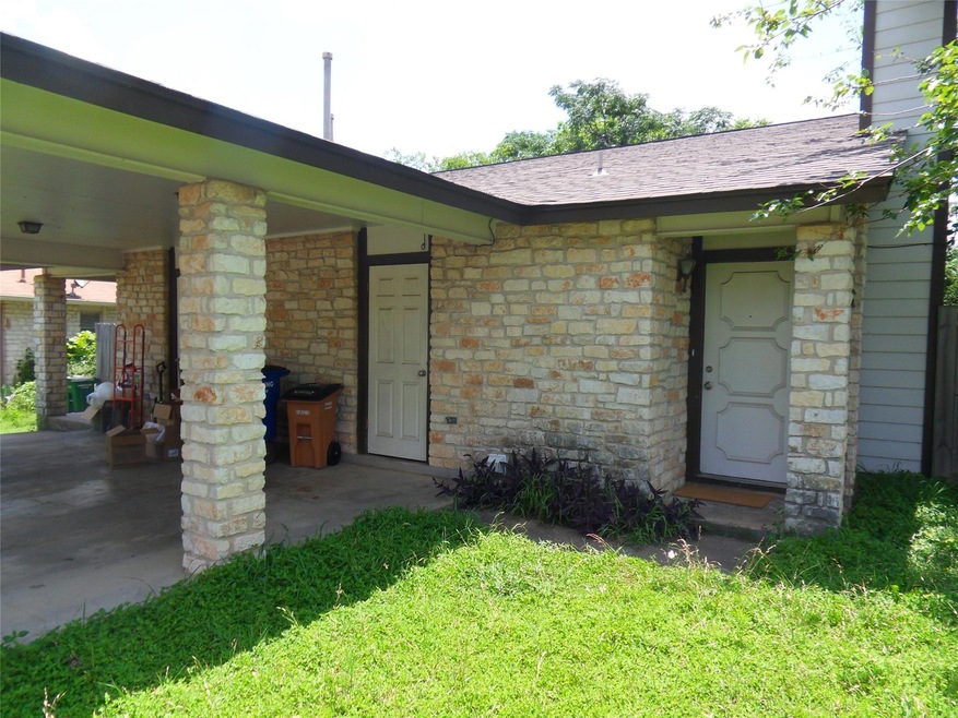 Property entrance with stone siding, a lawn, and 