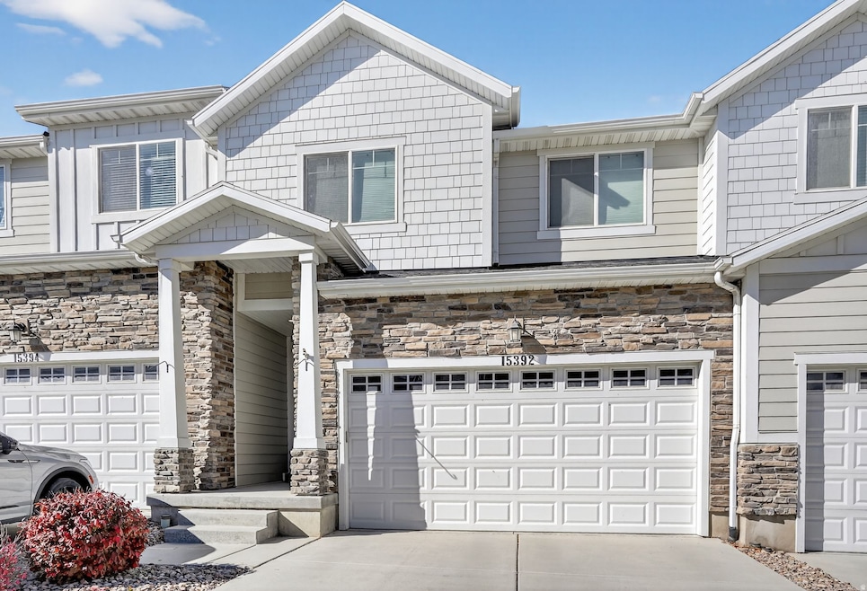 Craftsman-style home with stone siding, concrete driveway, and an attached garage