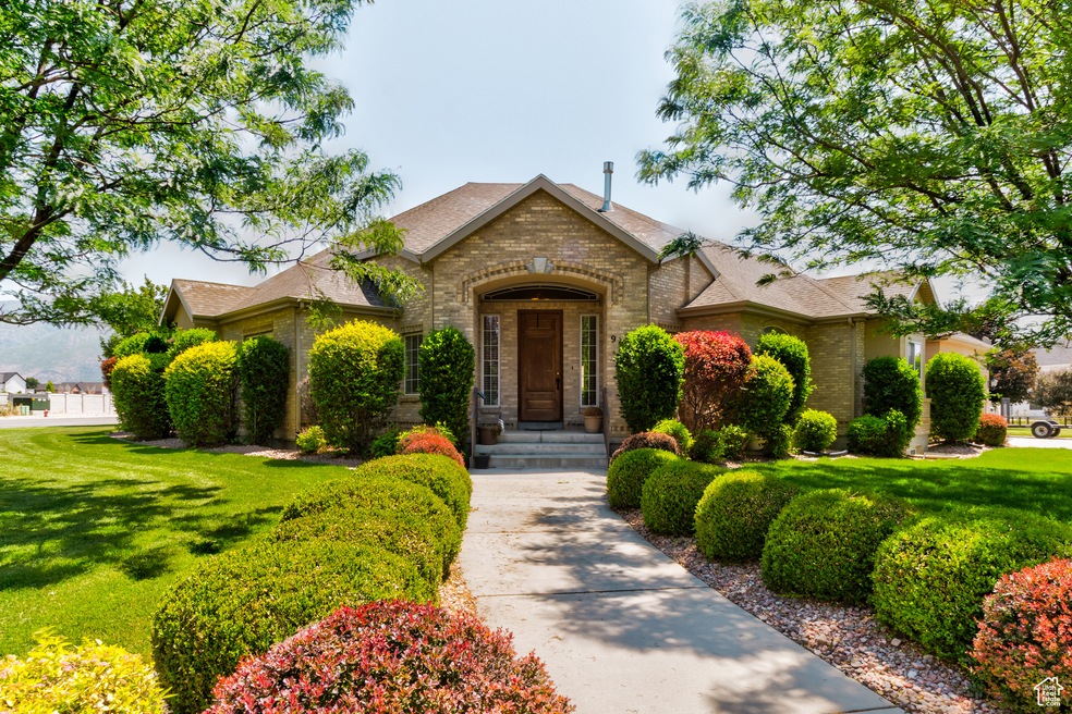 View of front facade with brick siding, a front yard, and roof with shingles