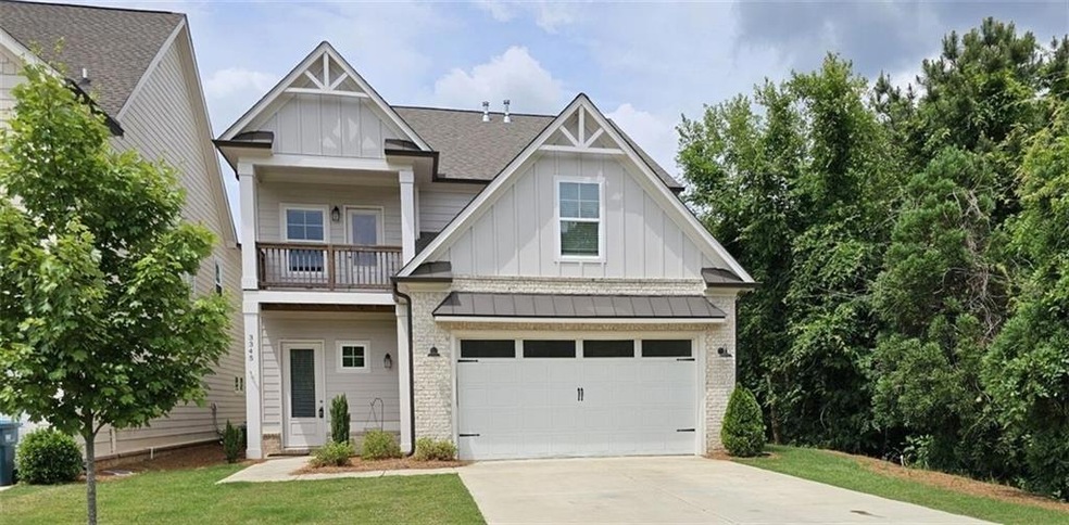 View of front of home featuring board and batten siding, concrete driveway, a balcony, and an attached garage