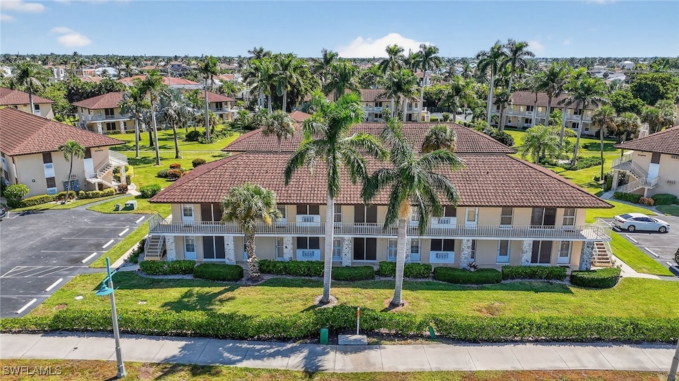 View of front facade featuring a tiled roof, uncovered parking, a front yard, and stairs