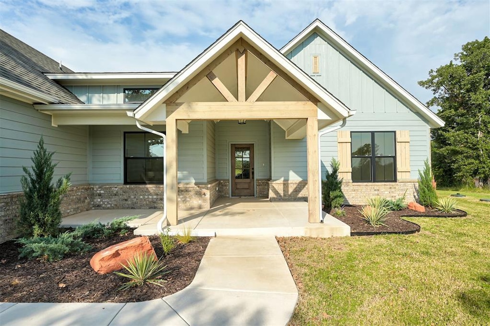 Front of the home with spacious covered porch and beautiful landscaping.