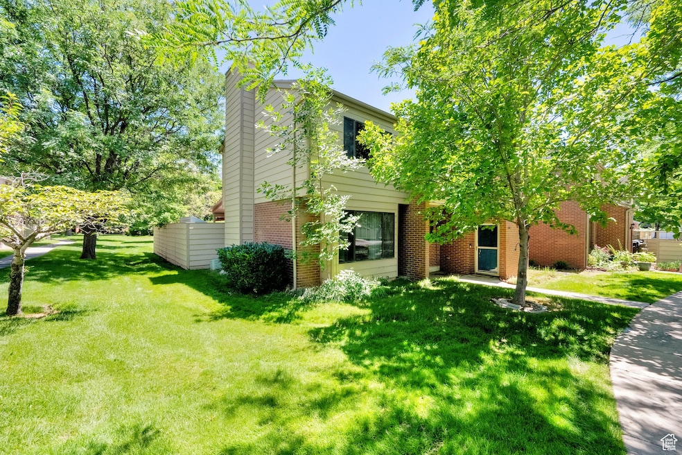 View of front facade with brick siding, a chimney, and a front lawn
