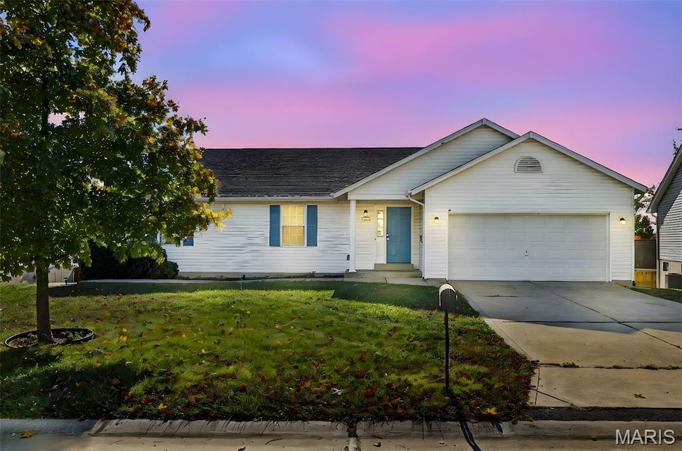 Ranch-style home featuring concrete driveway, a yard, and an attached garage