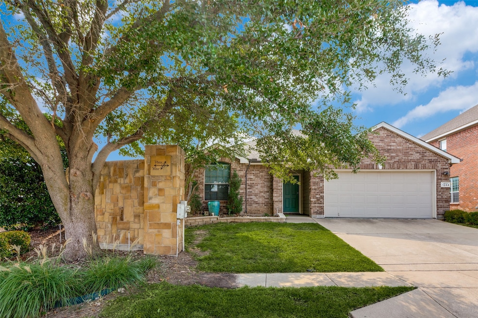 View of front of house with driveway, a garage, brick siding, and a front yard